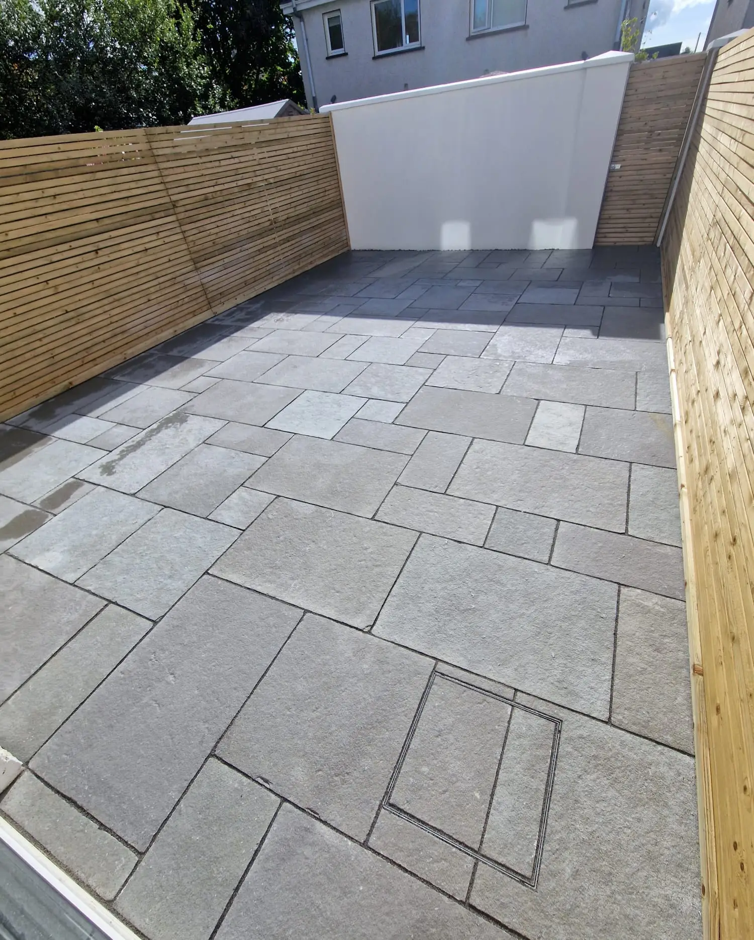 Stone patio with light timber fencing for added privacy in a modern Irish home