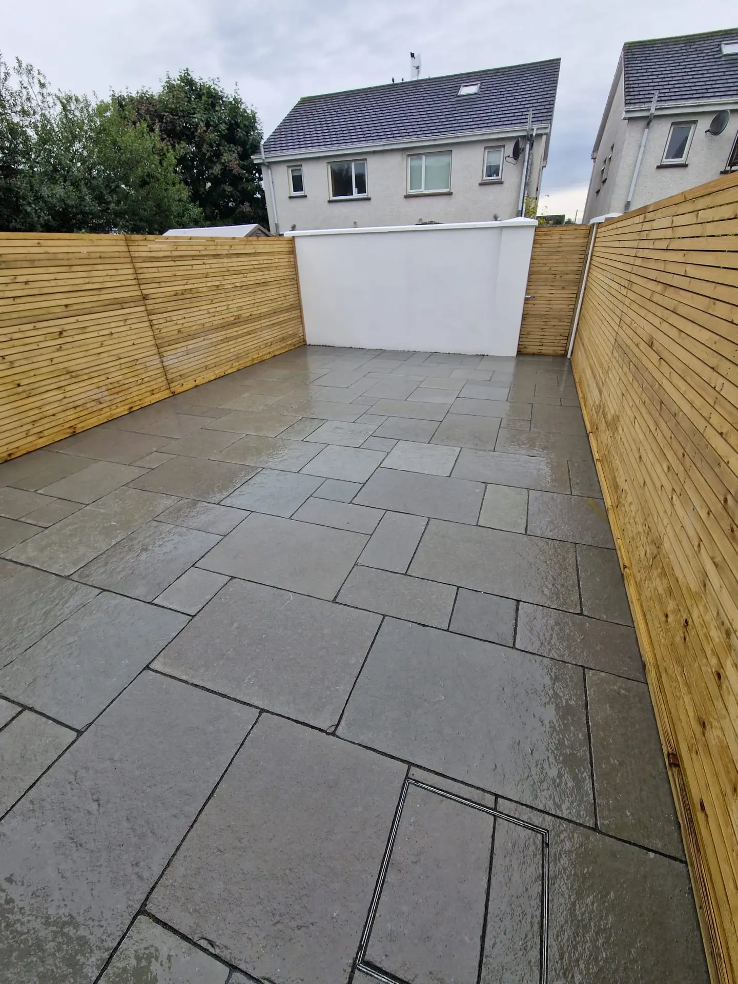 Wet patio finish with timber fencing on both sides in a private Clare garden